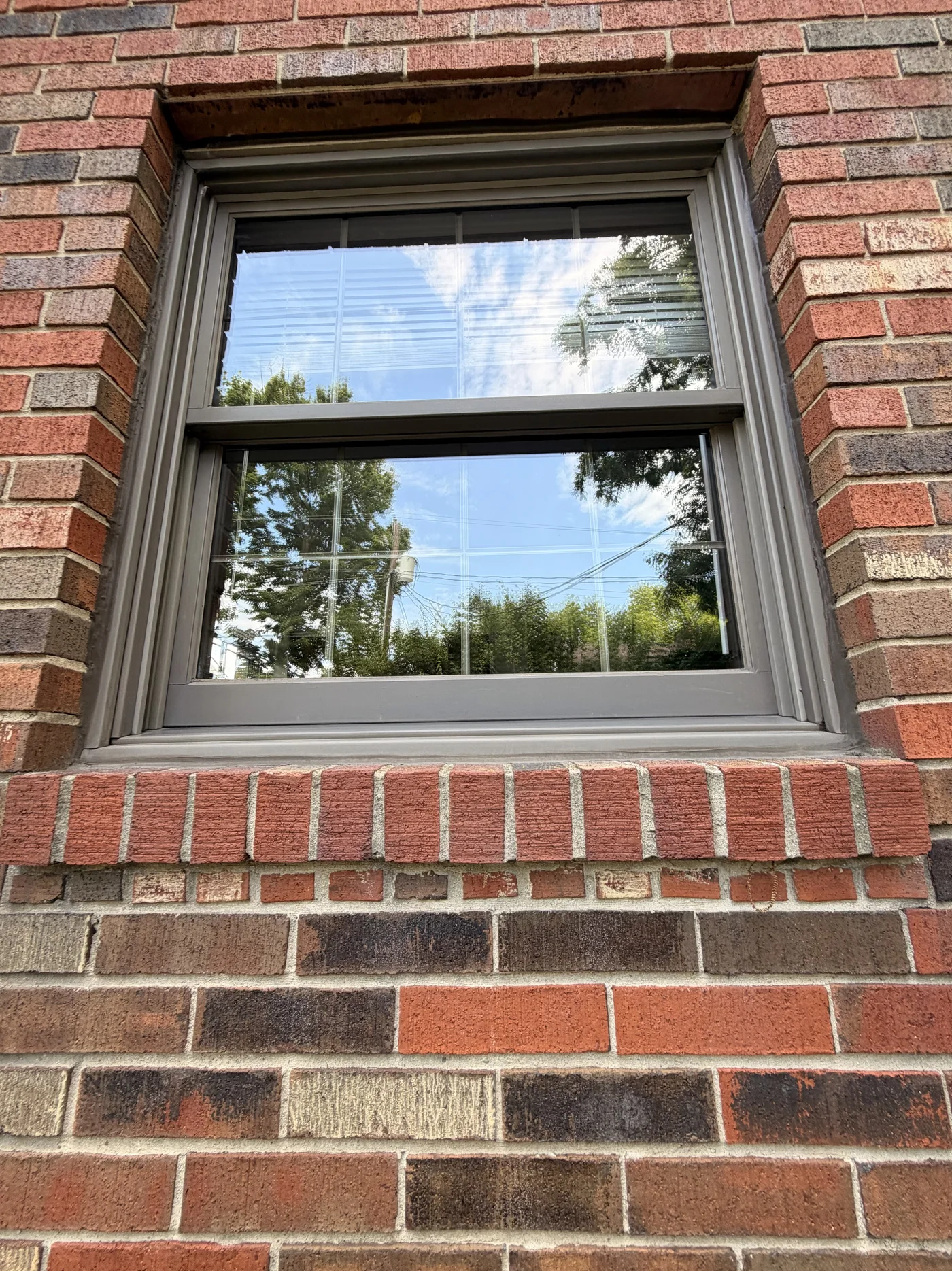 Exterior brick home window after professional cleaning in Middletown, Ohio showing clear glass